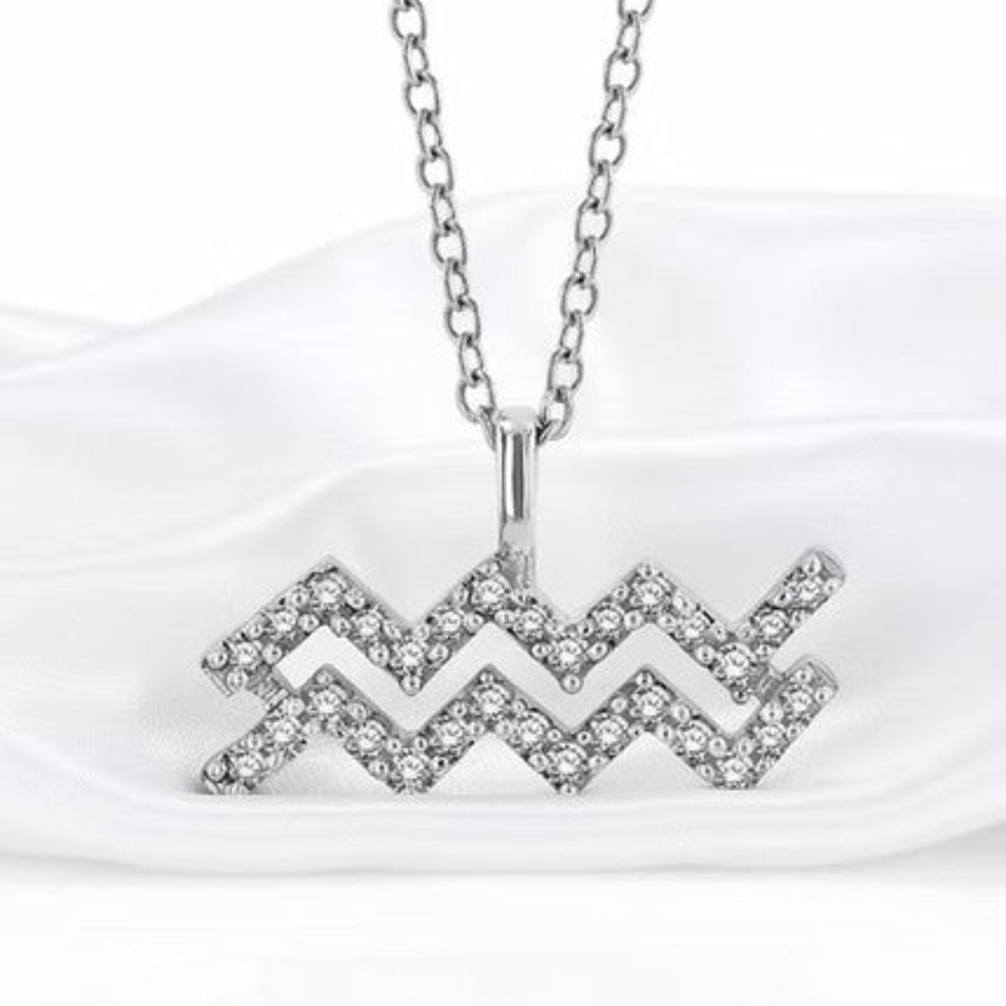 Silver Diamond Zodiac Pendant on White Silk Background
