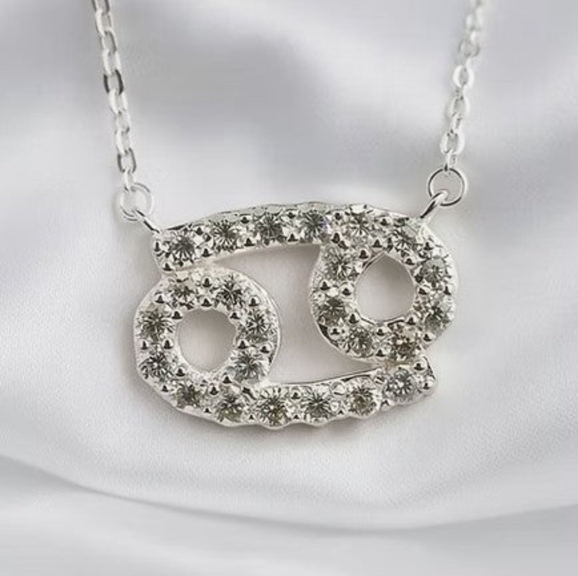 Moissanite Diamond Zodiac Necklace on White Silk Background