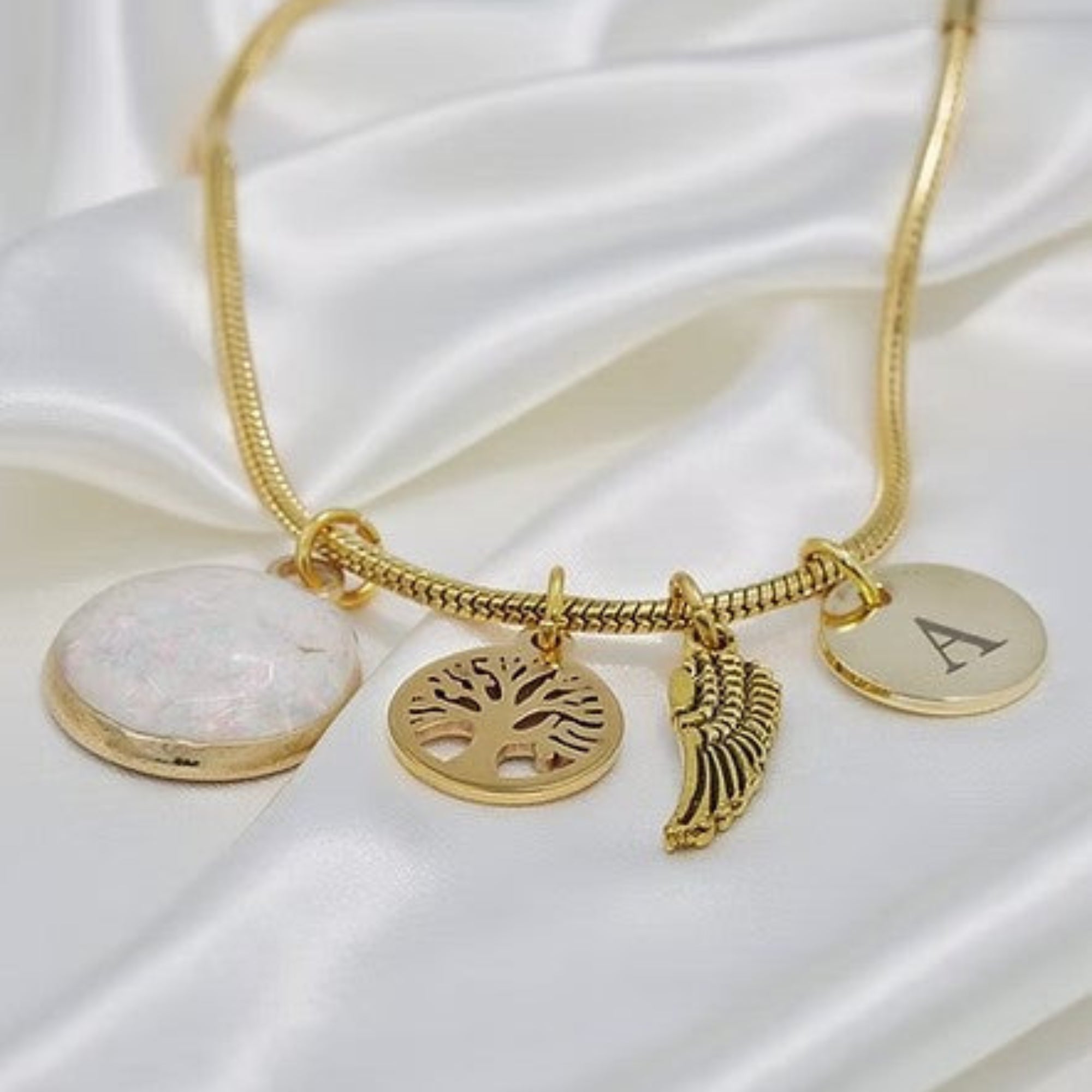 Gold Opal Charm Bracelet on White Silk Background