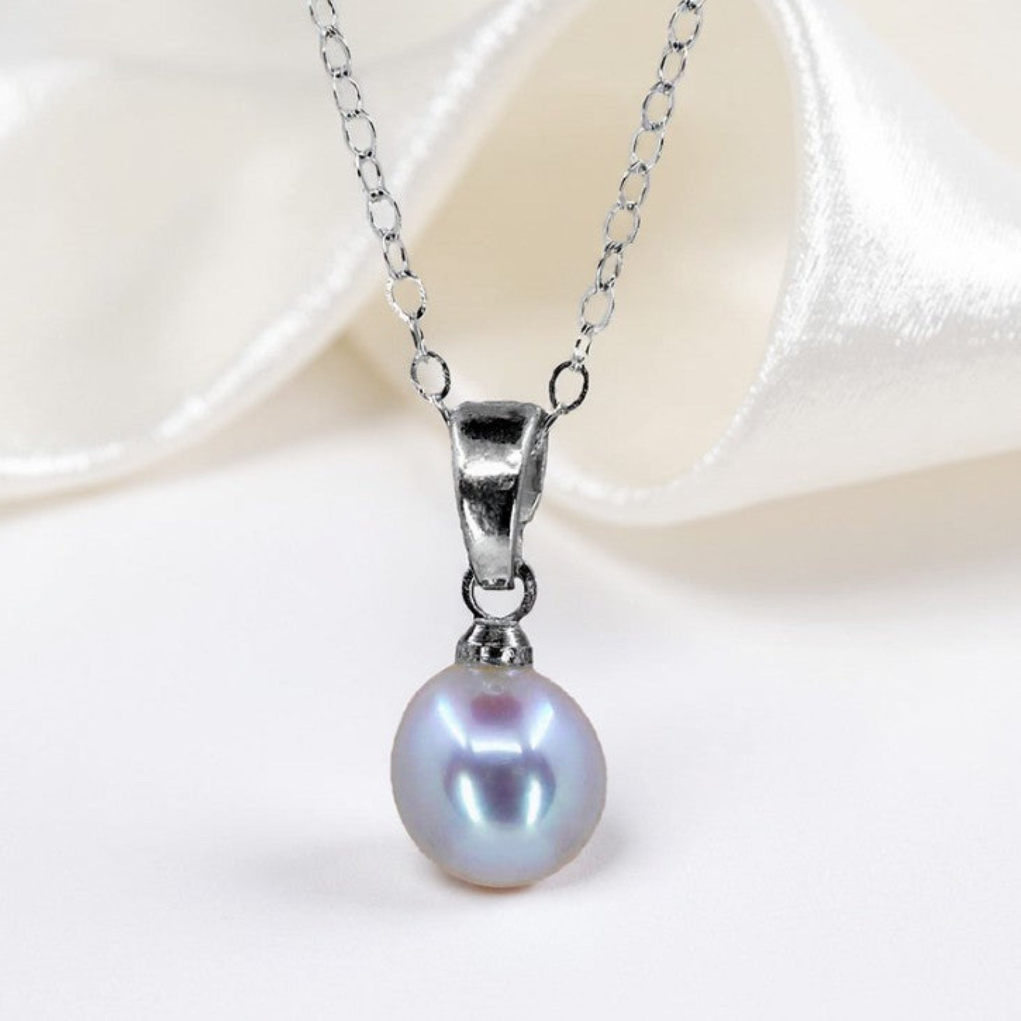 Natural Pearl Pendant On White Silk Background