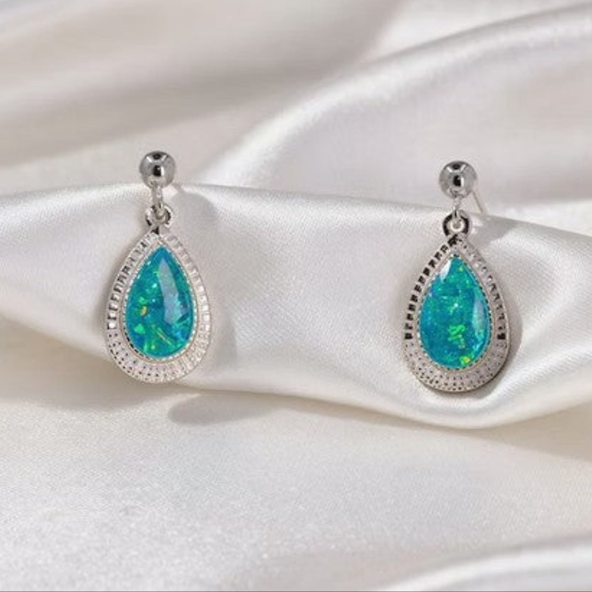 Silver Teardrop Earrings on Silk White Background